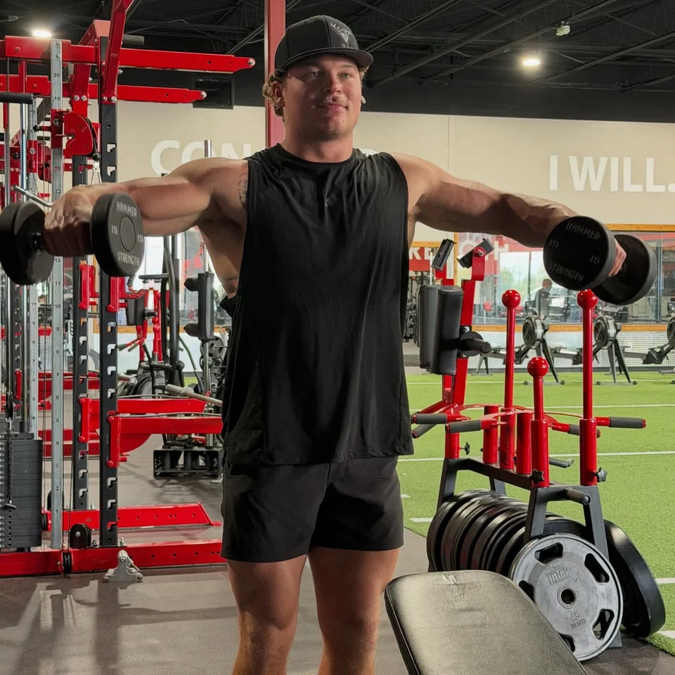 A T3 member lifting dumbbells on the training floor