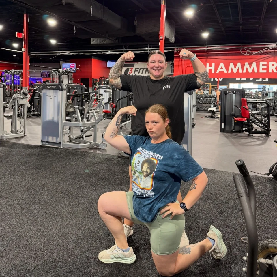 Two T3 members posing together on the workout floor